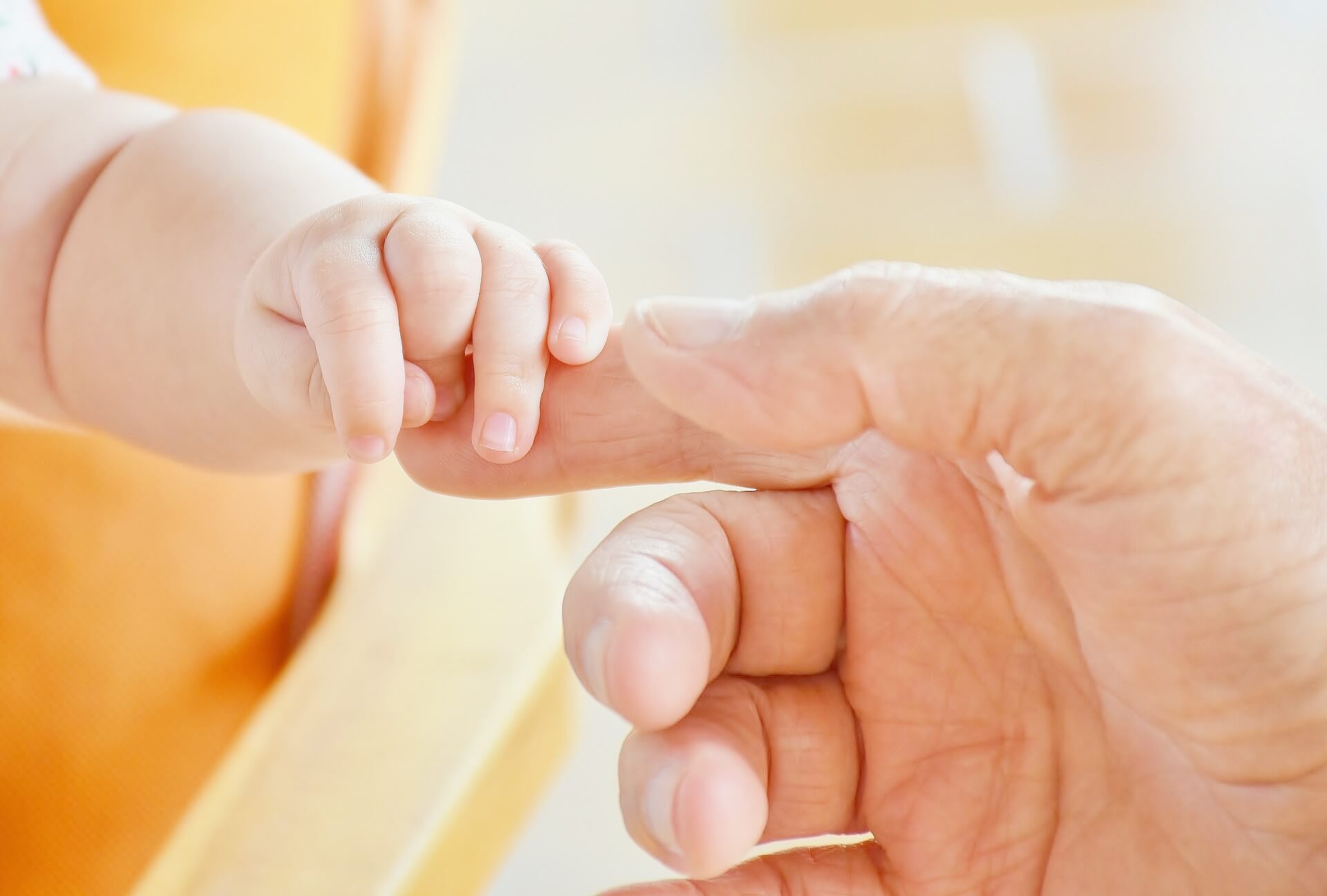 close-up-of-baby-holding-adult-hand