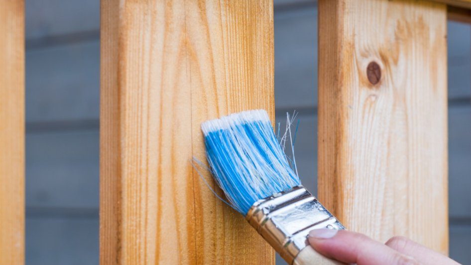 person-painting-wooden-fence-blue