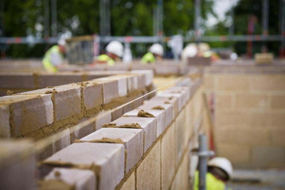 builders-constructing-brick-wall-on-construction-site