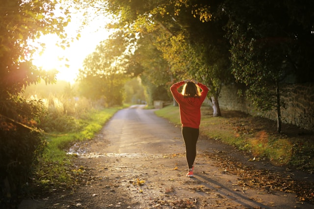 Woman walking on countryside pathway during daytime