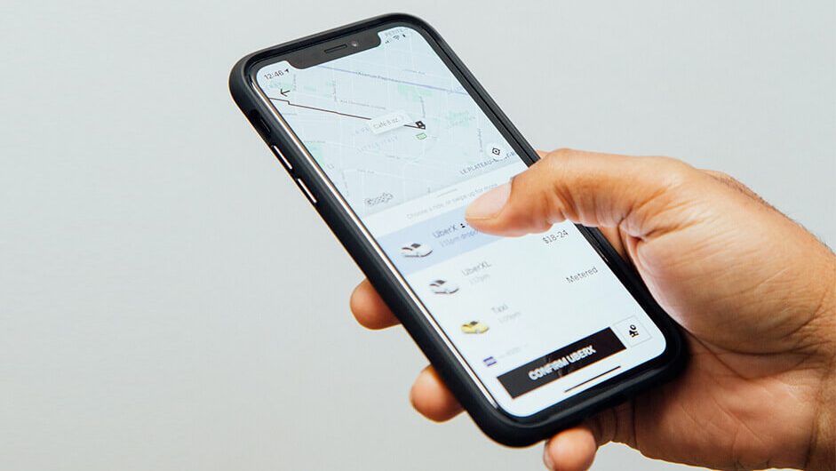 Hand holding iPhone with Uber app open