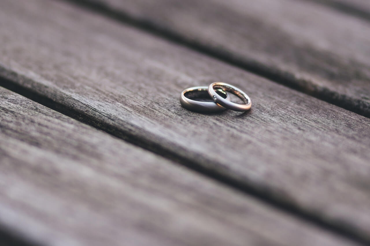 two-wedding-rings-on-wooden-table