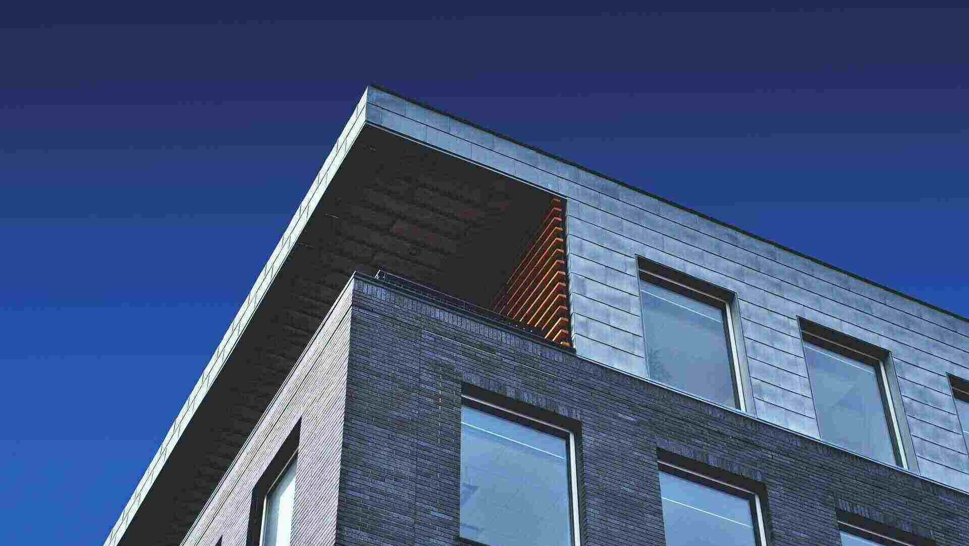 Grey block of modern flats against blue sky