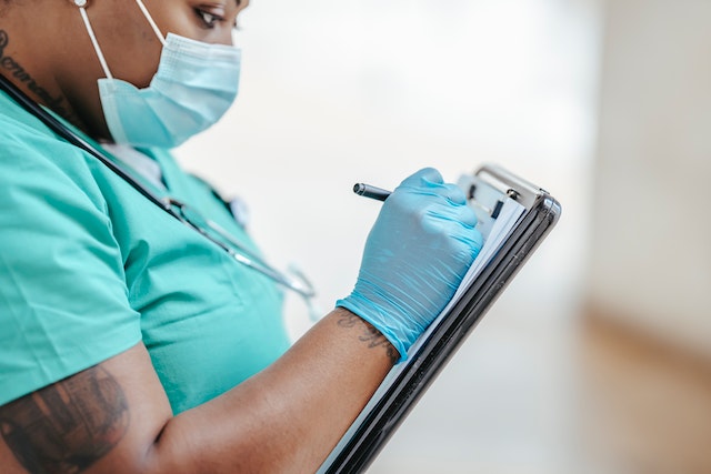 close-up-of-nurse-writing-notes-on-clipboard