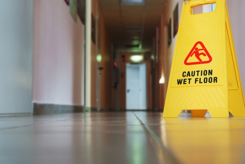 Yellow caution wet floor sign on tiled floor