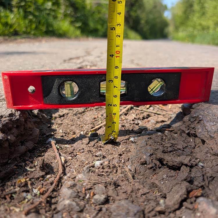 Close up of a spirit level measuring a pothole