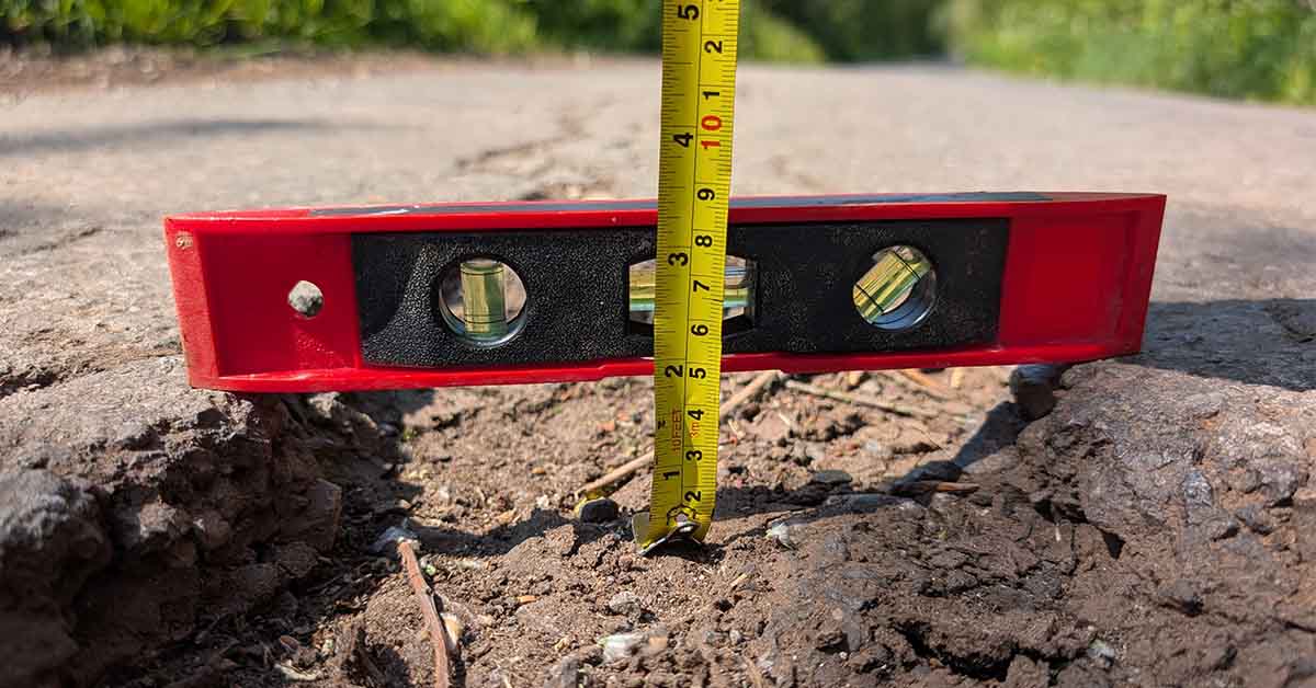 Close up of a spirit level measuring a pothole