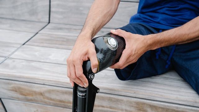 Close-up photo of man with his hand on a prosthetic limb