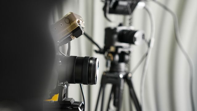 Close-up of professional video cameras on tripods in a studio setting